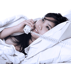 Pretty girl in bed, on the phone